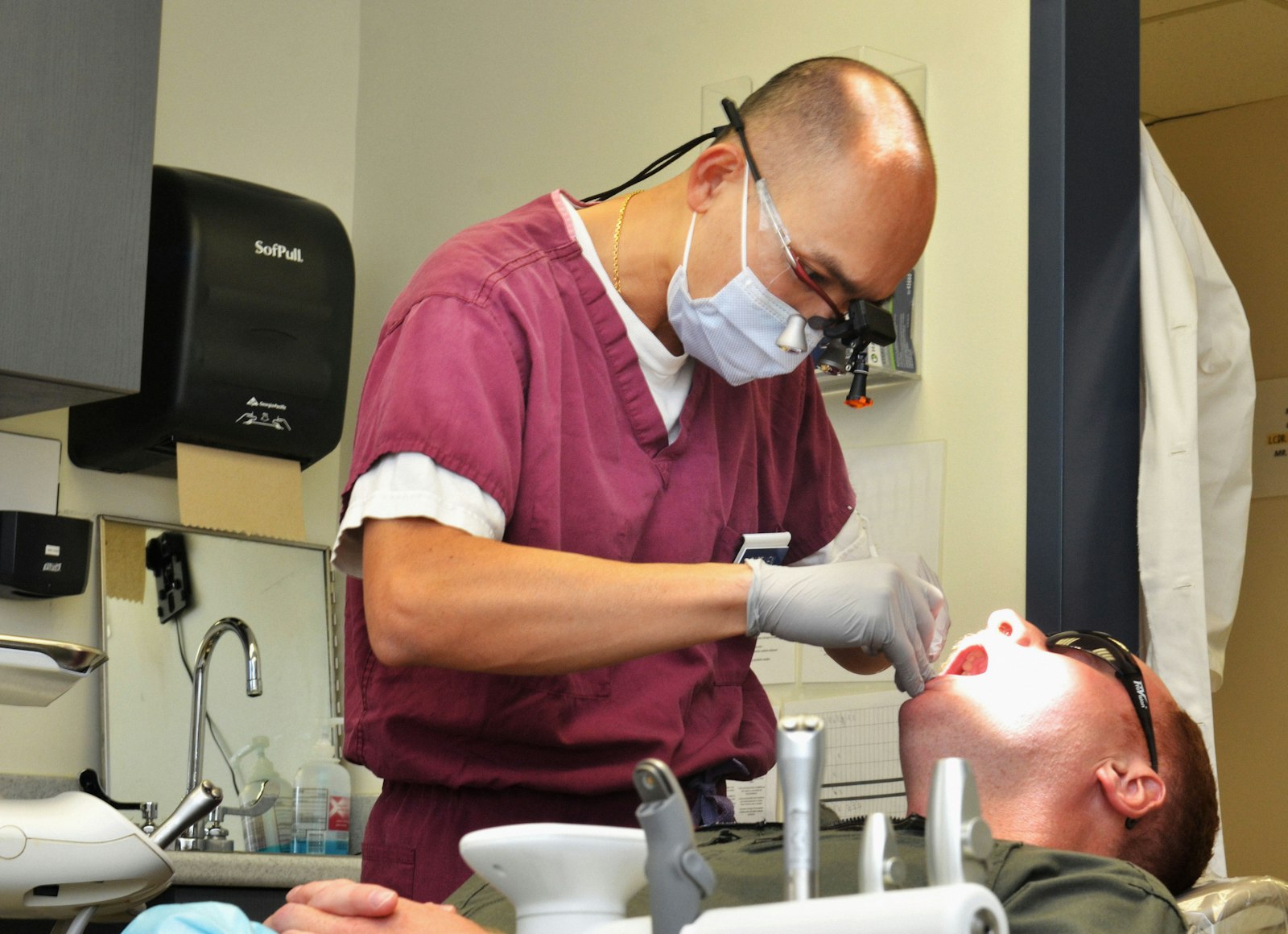 A dentist using magnification loupes during a precise procedure